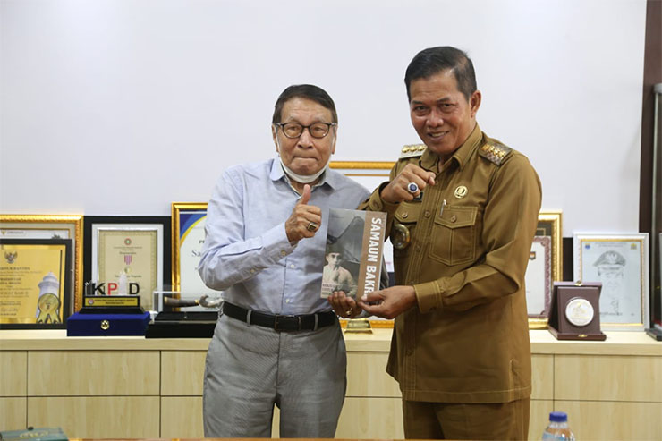 Anak dari KH Samaun Bakri, Fuad S. Bakri (Kiri) saat memberikan buku KH. Samaun Bakri kepada Walikota Serang Syafrudin (Kanan). (Foto:Istimewa)