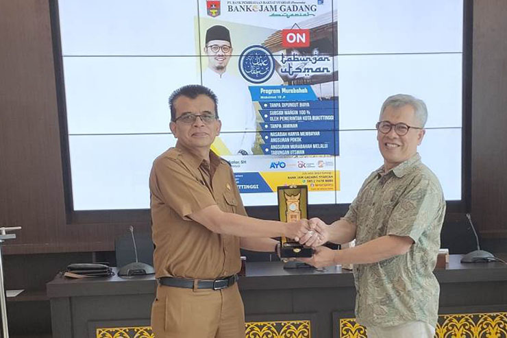 Kepala Dinas Koperasi UKM dan Tenaga Kerja Kota Bukittinggi, Noverdi (kiri), saat memberikan cinderamata ke Kepala Dinas Koperasi dan UMKM Kota Cilegon, Didin S. Maulana, di kantor Dinas Dinas Koperasi UKM dan Tenaga Kerja Kota Bukittinggi, Senin (24/7/2023). DOK: RULIE SATRIA 
