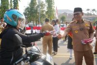 Wali Kota Cilegon, Helldy Agustian, saat membagikan bendera merah putih ke masyarakat Kota Cilegon yang melintas di depan gedung Pemkot Cilegon, Senin (7/8/2023). ISTIMEWA 