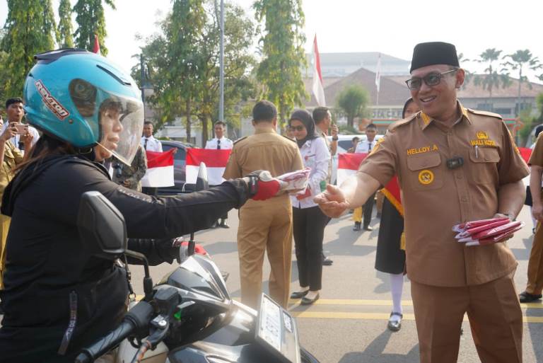 Wali Kota Cilegon, Helldy Agustian, saat membagikan bendera merah putih ke masyarakat Kota Cilegon yang melintas di depan gedung Pemkot Cilegon, Senin (7/8/2023). ISTIMEWA 