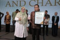Gubernur Provinsi Banten, Andra Soni saat menerima Penghargaan yang diberikan oleh Ketua Pokja Ekbispar Banten, Susi Kurniawati, dengan Program “Bang Andra” nya, dalam Acara Ekbispar Awards 2026 “Awarding And Charity”. (Foto: Istimewa)
