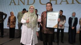 Gubernur Provinsi Banten, Andra Soni saat menerima Penghargaan yang diberikan oleh Ketua Pokja Ekbispar Banten, Susi Kurniawati, dengan Program “Bang Andra” nya, dalam Acara Ekbispar Awards 2026 “Awarding And Charity”. (Foto: Istimewa)