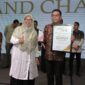 Gubernur Provinsi Banten, Andra Soni saat menerima Penghargaan yang diberikan oleh Ketua Pokja Ekbispar Banten, Susi Kurniawati, dengan Program “Bang Andra” nya, dalam Acara Ekbispar Awards 2026 “Awarding And Charity”. (Foto: Istimewa)