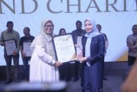 Bupati Serang, Hj. Ratu Rachmatuzakiyah saat menerima Penghargaan yang diberikan oleh Ketua Pokja Ekbispar Banten, Susi Kurniawati, dengan Program “Kemudahan Perizinan Berusaha bagi Investor di Kabupaten Serang” nya, dalam Acara Ekbispar Awards 2026 “Awarding And Charity”. (Foto: Istimewa)