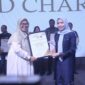 Bupati Serang, Hj. Ratu Rachmatuzakiyah saat menerima Penghargaan yang diberikan oleh Ketua Pokja Ekbispar Banten, Susi Kurniawati, dengan Program “Kemudahan Perizinan Berusaha bagi Investor di Kabupaten Serang” nya, dalam Acara Ekbispar Awards 2026 “Awarding And Charity”. (Foto: Istimewa)